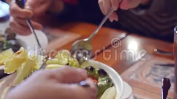 一家人在澳门享用美味的烤什锦蔬菜炒蛤蜊炸鳕鱼球视频的预览图