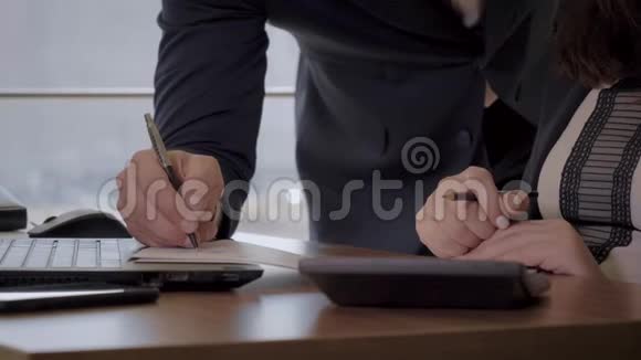 在桌面上用钢笔书写图表的办公室工作人员的手视频的预览图