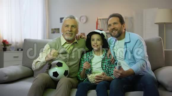兴奋的爷爷爸爸和儿子为国家足球队获胜而高兴回家了视频的预览图
