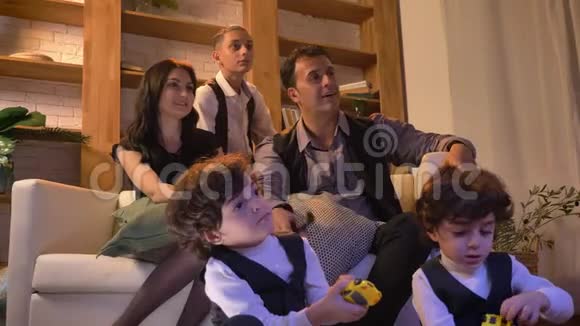 阿拉伯家庭坐在客厅沙发上紧张地看电视然后变得非常快乐的肖像视频的预览图