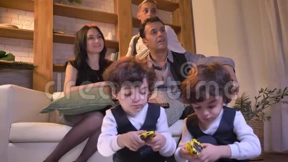 阿拉伯家庭坐在客厅的沙发上的肖像变得非常高兴看电视视频的预览图