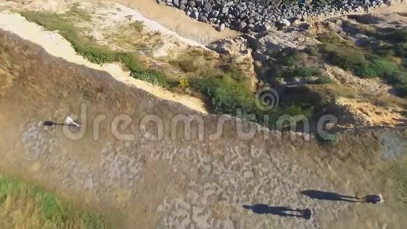 从无人机垂直向下射击一男一女站在悬崖上长长的影子视频的预览图