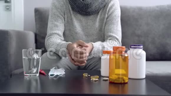 药片胶囊和温度计放在桌子上男子服用药物视频的预览图