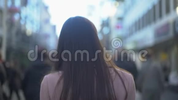 年轻女子走在拥挤的商业街旅游目的地后景视频的预览图
