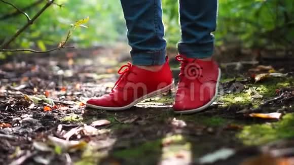 穿着红色运动鞋的女足美丽的绿色森林视频的预览图