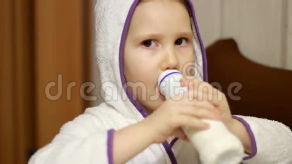 小女孩喝着一瓶牛奶饮料凯菲尔微笑着从酸奶中露出一个白色的胡子视频的预览图