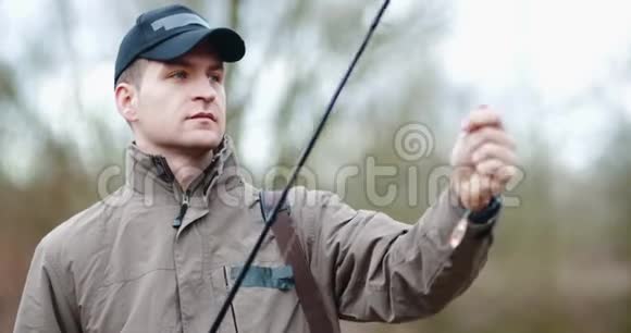 在湖边准备鱼竿的自信男子视频的预览图