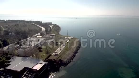 用无人驾驶飞机对希腊卡拉马里亚塞萨洛尼基海岸线旁的一条道路进行空中射击视频的预览图