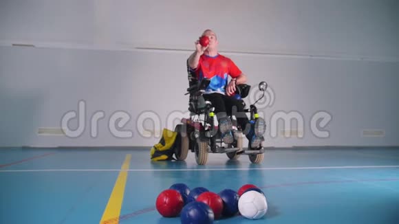 坐轮椅的残疾人扔一个蓝色的小球波西亚蓝色红色白色视频的预览图
