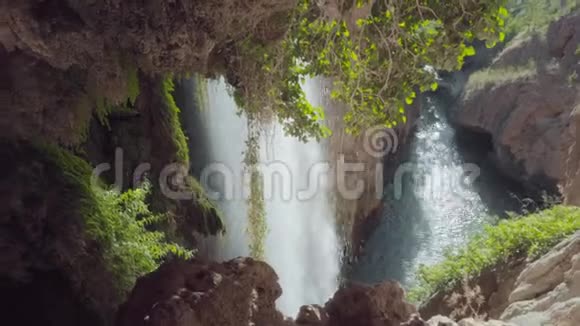 洞穴中的Id瀑布热带雨林景观水流环绕着苔藓的岩石和美丽的丛林景色视频的预览图