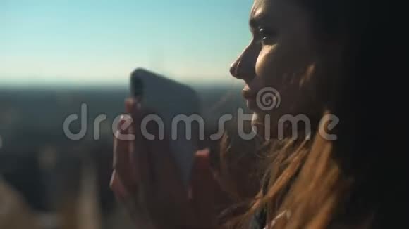漂亮的年轻女人在Skydeck智能手机上聊天合理的漫游费视频的预览图
