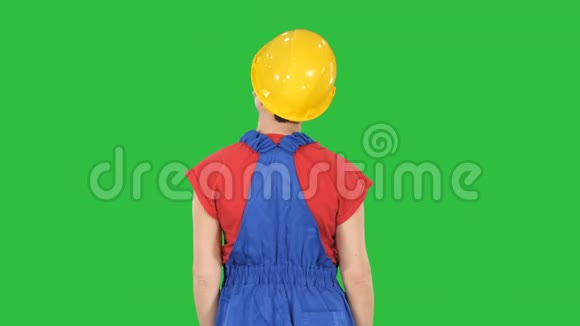 女建筑工人双手放在臀部看着绿色屏幕上的东西Chroma键视频的预览图
