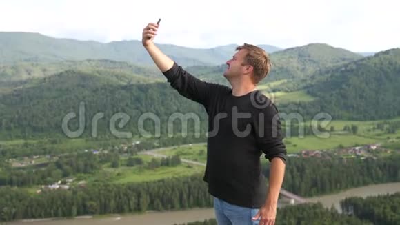 年轻快乐的人在美丽的群山中拍下手机视频的预览图