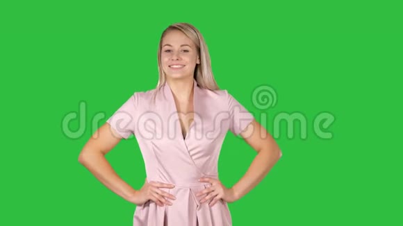 美丽的年轻女人走路双手放在臀部在绿色屏幕上说话Chroma键视频的预览图