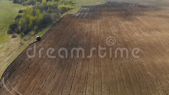 一片风景如画的农田肥沃的土地和充满能量的红色拖拉机犁地视频的预览图