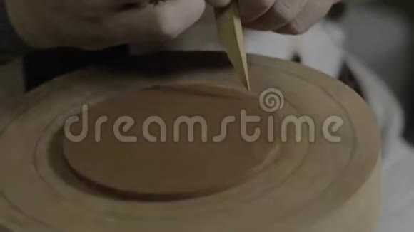 陶土师傅用木刀削掉一个均匀的陶土圈为宜兴陶土的茶壶盖上盖子手工粘土视频的预览图