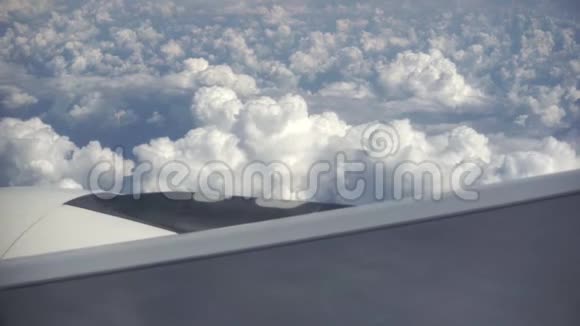 从窗外看到一架飞机高高地飞在地面上美丽堆白云和天空视频的预览图