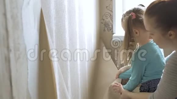 一个小女孩帮助她的母亲在房间里修理把墙上的旧墙纸撕掉视频的预览图