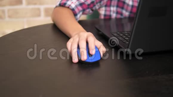 特写镜头电脑鼠标在一个十几岁的男孩手中使用笔记本电脑视频的预览图