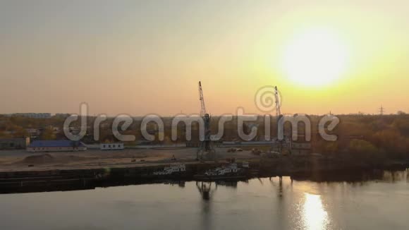 在河港黎明时用拖轮和货物起重机进行空中摄影视频的预览图