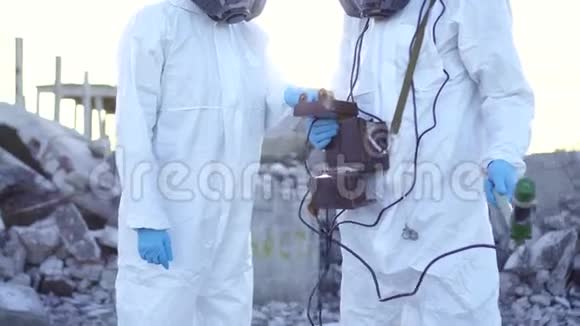 描绘了两名穿着防护服和口罩的科学家和一名辐射监测员步行测量辐射视频的预览图