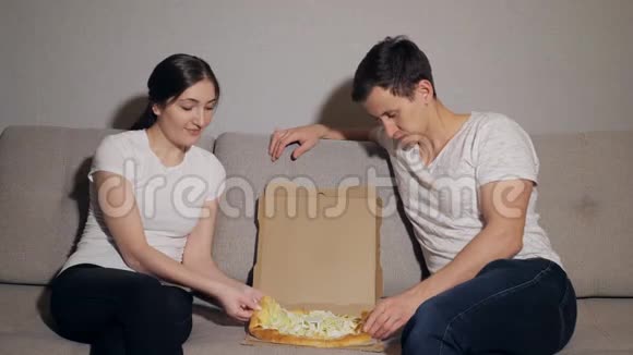 漂亮的年轻夫妇穿着便装吃披萨视频的预览图
