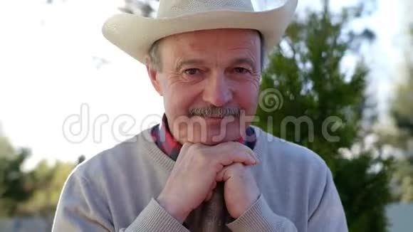 戴帽子的成熟男人微笑着用手做好牌视频的预览图