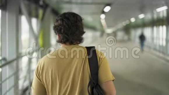 米黄色T恤男子在隧道行走后景视频的预览图