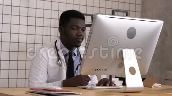 非裔美国医生在工作看他的电脑显示器视频的预览图