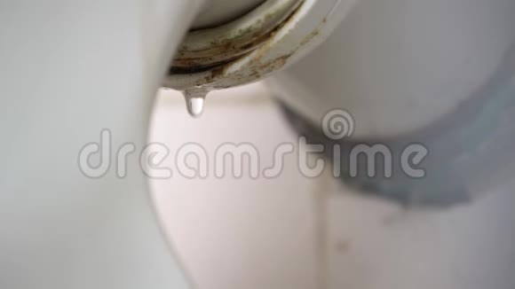 由于管道堵塞或部件磨损而从厕所漏水污浊的管道把臭水滴在马桶后面视频的预览图