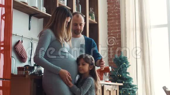 小女孩早上抱着妈妈怀孕的肚子视频的预览图