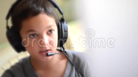 儿童开心地听音乐在电脑上用耳机在户外播放视频的预览图