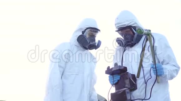 两名穿着防护服和面罩的科学家在废墟的背景下测量了辐射视频的预览图