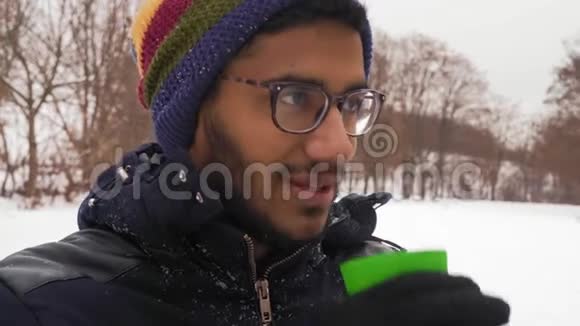 戴眼镜的印第安人在森林的冬天喝咖啡视频的预览图