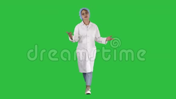 友好的女医生在绿色屏幕上行走和与相机交谈Chroma键视频的预览图