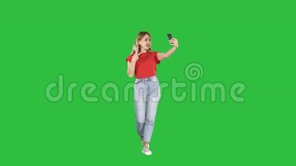 精彩的白色女性模特在绿色屏幕上行走时自拍Chroma键视频的预览图