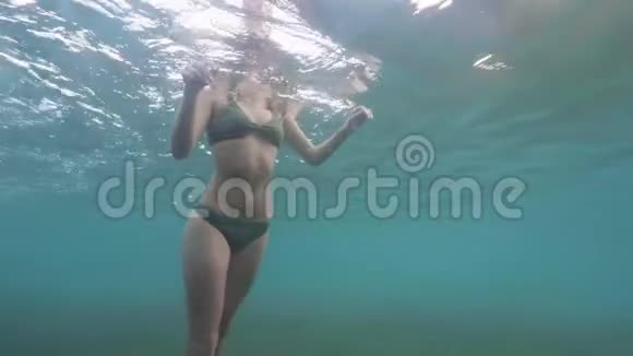 水下观看穿着透明海洋泳衣的女性身体穿比基尼的年轻女子在蓝海上游泳女孩浮潜视频的预览图