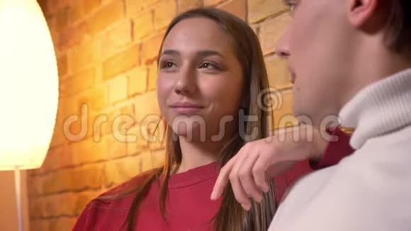 年轻的白种人女孩坐在沙发上喝着酒在舒适的家里和她的朋友交谈的特写照片视频的预览图