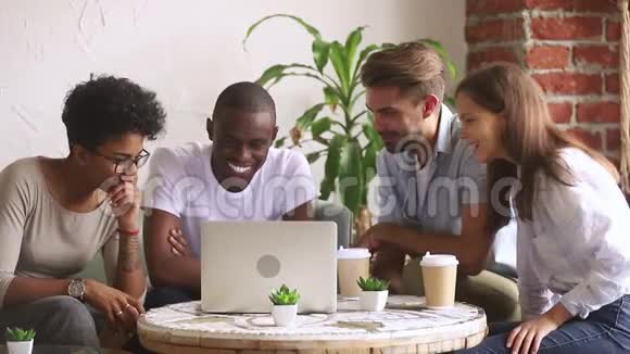 快乐的多元文化朋友看着笔记本电脑玩着看喜剧视频的预览图