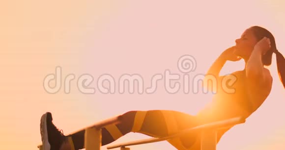 在海滩日落的户外健身站上表演吊腿动作的真正健康和健康的的竞争镜头视频的预览图