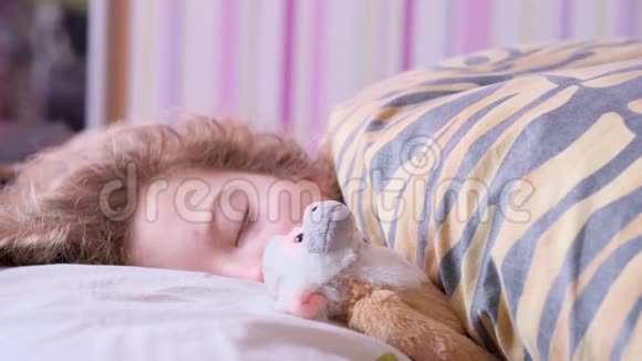 小女孩和一只玩具猴子睡在床上视频的预览图