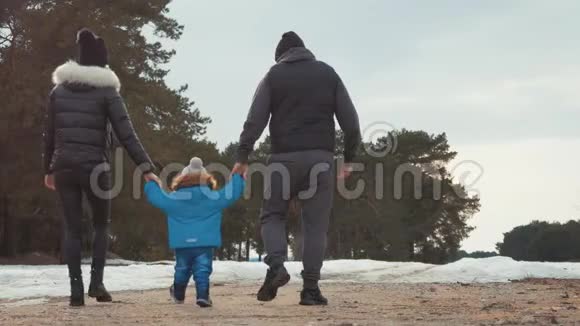 幸福的家庭在冬天的森林里散步亲子关系季节和人的概念视频的预览图
