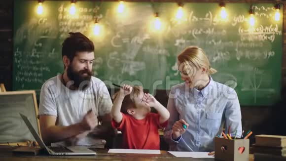 4k有男教师和女教师的男生在黑板的背景下在教室里画画视频的预览图