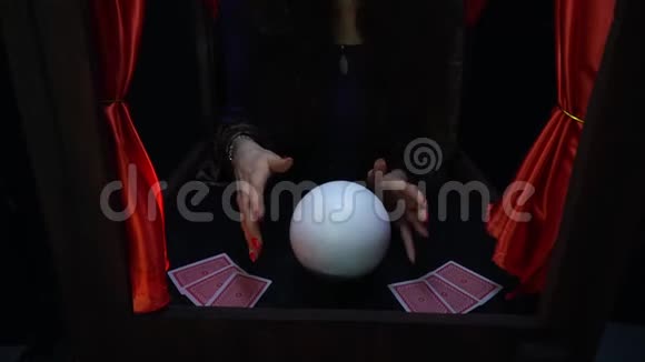 神秘的算命先生浓妆艳抹红指甲在水晶球上变魔术视频的预览图
