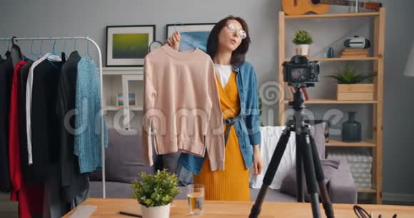 女造型师在网上博客上录制视频展示时髦服装的谈话内容视频的预览图