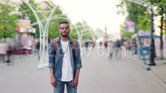 长胡子的阿拉伯人独自背着背包站在城市街道上视频的预览图