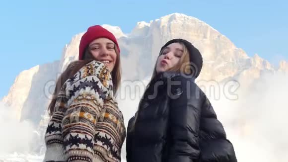 两个年轻的女人站在一座山的背景上摆着姿势视频的预览图