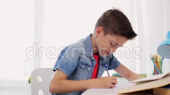 一个在家写书到笔记本的累男孩视频的预览图