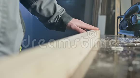 一个男木匠的特写他的手检查木板加工后的光滑性和适宜性视频的预览图