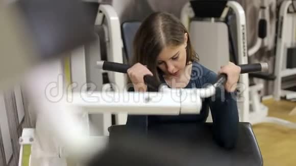 一个女孩从事一个健身房与哑铃她泵不同的肌肉群视频的预览图